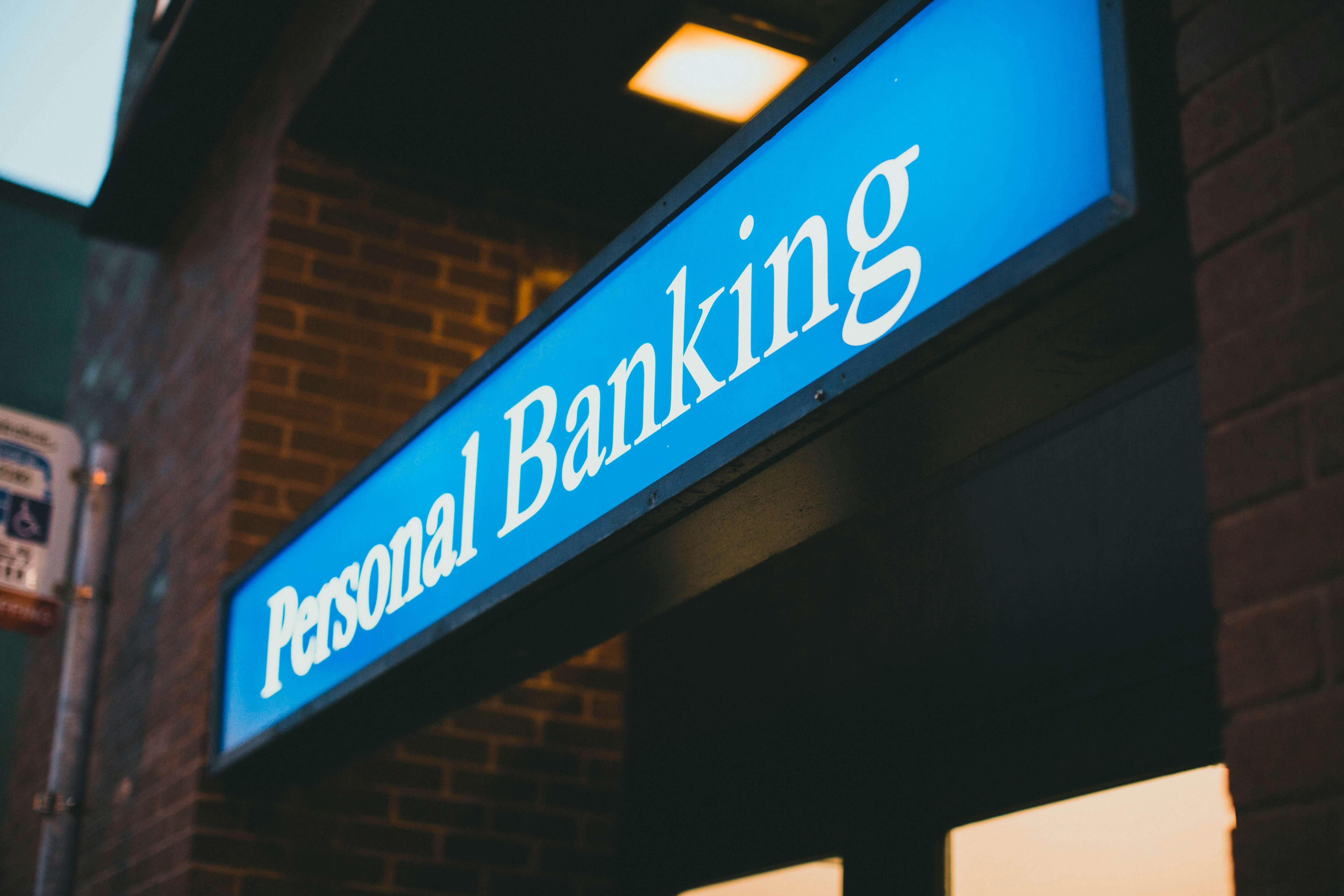 A diagonal look at a blue and white sign that says personal banking.