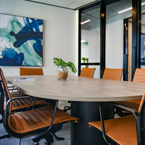 Clean office with a large table with eight chairs.